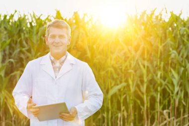 Çiftliğinde dijital tablet ile olgun bilim adamı gülümseyen