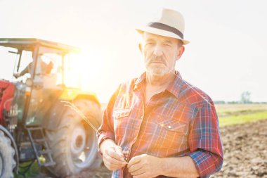 Kendine güvenen üst düzey Çiftçi traktör çiftliğinde karşı daimi portresi