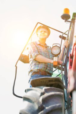 Çiftlikte traktör kullanan kendine güvenen çiftçi