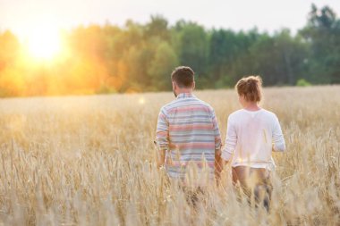 Çiftlikteki ekinlerin arasında yürüyen çiftlerin dikiz görüntüsü