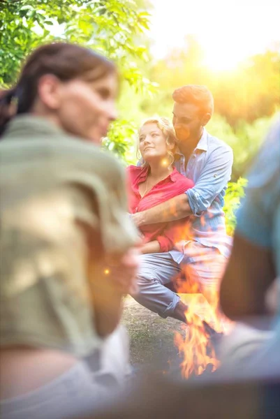Muž Objímající Svou Ženu Zatímco Sedí Lavičce Táboře Oheň — Stock fotografie