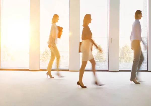 Ofiste Çalışan Işadamları Arka Planda Sarı Lens Işığıyla Yürüyorlar — Stok fotoğraf