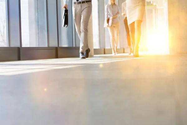 Business People Walking While Talking Office Hall Yellow Lens Flare — Stock Photo, Image