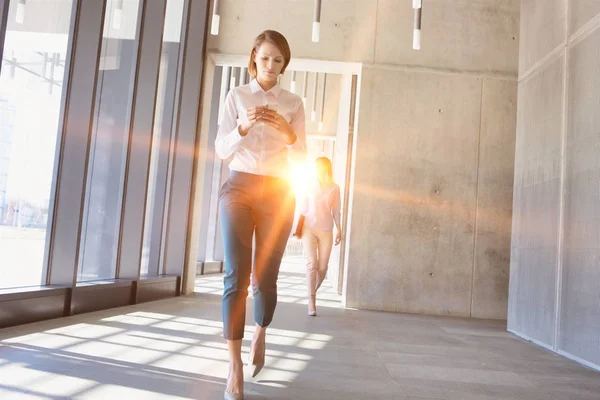 Businesswoman Camminare Mentre Utilizza Smartphone Sala Ufficio Con Bagliore Lente — Foto Stock