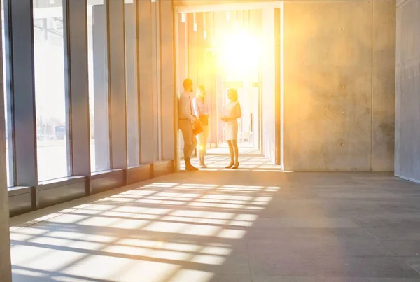 Business People Walking While Talking Office Hall Yellow Lens Flare — Stock Photo, Image