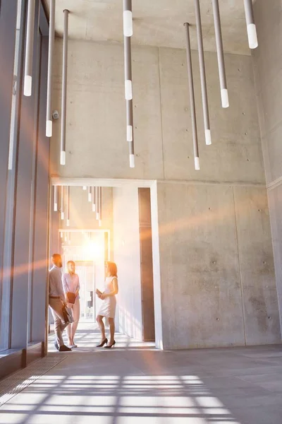 Business People Walking While Talking Office Hall Yellow Lens Flare — Stock Photo, Image