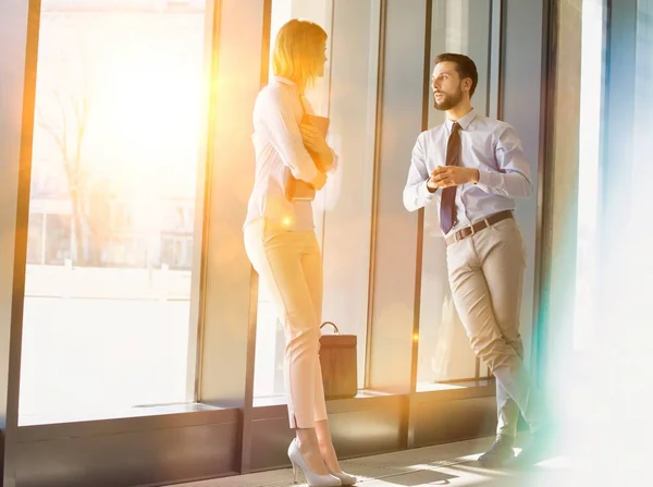 Businessman Talking Businesswoman Office Hall Yellow Lens Flare — Stock Photo, Image