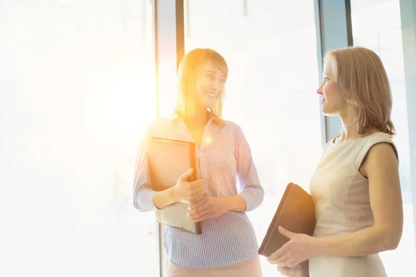 Affärskvinnor Diskuterar Planer När Går Kontorslokal Med Gul Lins Blossa — Stockfoto