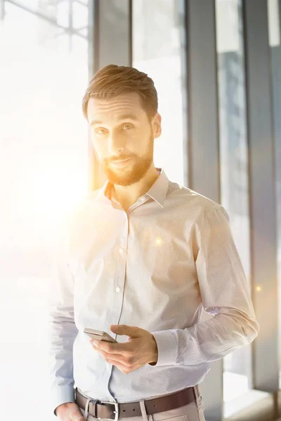 Jonge Aantrekkelijke Zakenman Glimlachen Tijdens Het Gebruik Van Smartphone Kantoor — Stockfoto