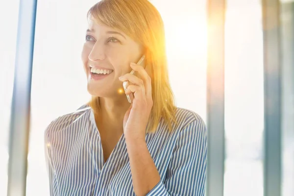 黄色のレンズフレアとスマートフォンで話しているビジネスマンの女性 — ストック写真