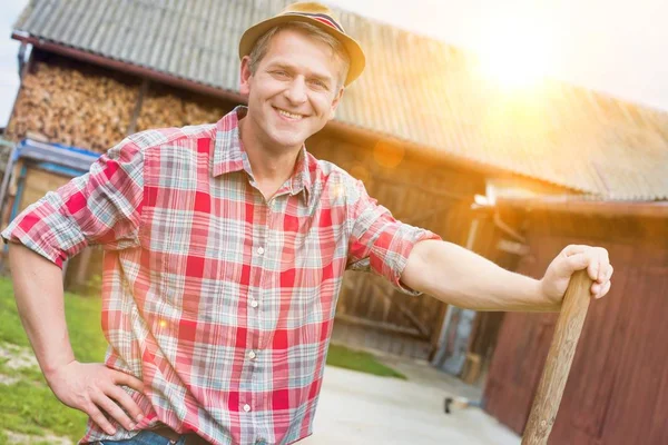 Mature Farmer Standing While Holding Shovel Barn Yellow Lens Flare — Stock Photo, Image