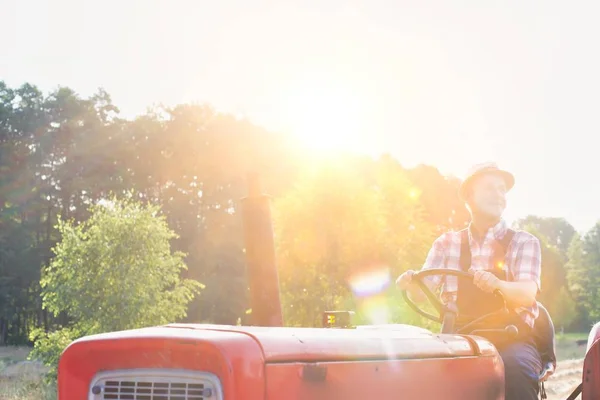 有信心的农民在阳光灿烂的日子驾驶拖拉机到农场 — 图库照片