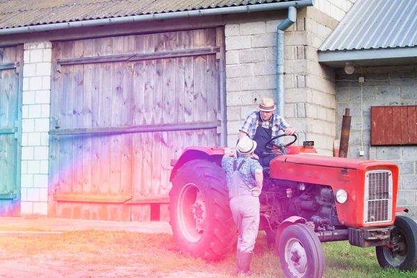 阳光下农民在拖拉机上交谈的低视角图像 — 图库照片