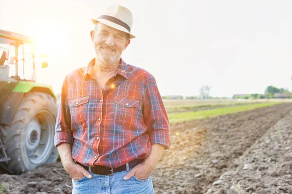 Kendine güvenen üst düzey Çiftçi traktör çiftliğinde karşı daimi portresi
