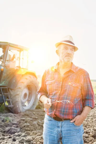 Kendine güvenen üst düzey Çiftçi traktör çiftliğinde karşı daimi portresi