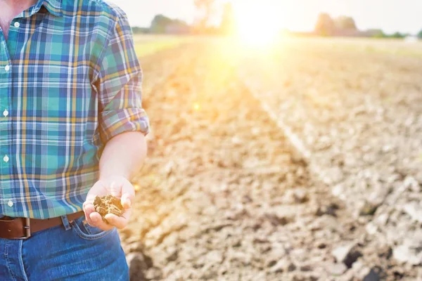 Landwirt Hält Erde Während Mit Gelbem Linsenblitz Hintergrund Auf Einem — Stockfoto