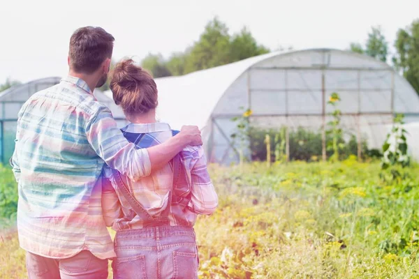 Vista Trasera Pareja Mirando Las Plantas Que Crecen Granja —  Fotos de Stock