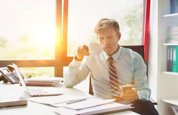 Business people working in office with strong lens flare in background