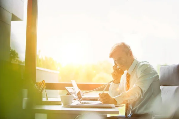 Mature Businessman Talking Phone Office Yellow Lens Flare Background — Stock Photo, Image