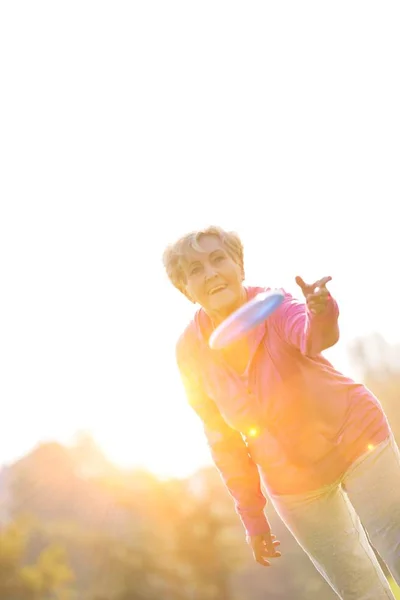 Lachende Gezonde Senior Vrouw Gooien Schijf Park — Stockfoto