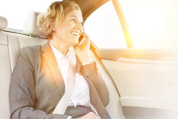 Businesswoman Smiling While Talking Smartphone Yellow Lens Flare Background — Stock Photo, Image