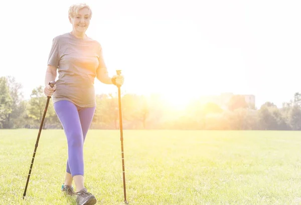 Actieve Senior Vrouw Met Trekking Palen Wandelen Het Park — Stockfoto