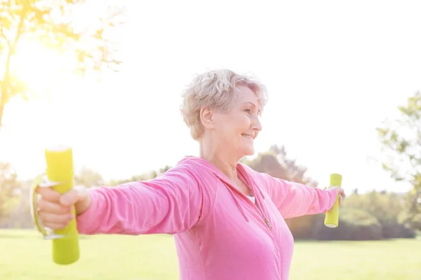 Senior Kvinna Med Armarna Utsträckta Lyft Hantlar Park — Stockfoto