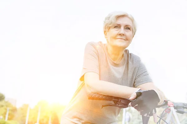 Femme Âgée Confiante Souriant Faisant Vélo Dans Parc — Photo