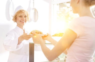 Şef garsona yemek veriyor. Restorandaki müşteriye servis edilsin diye.