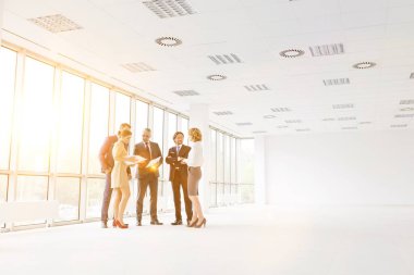 Yeni ofiste pencereye karşı dururken tartışan iş arkadaşları