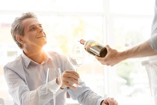 Waiter Pouring Red Wine Mature Customer Wineglass Restaurant Yellow Lens — Stock Photo, Image