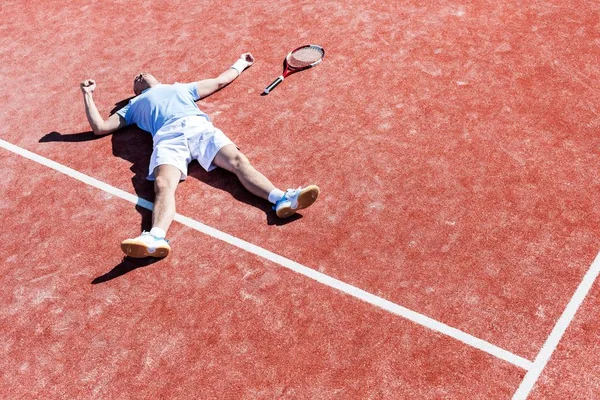 由于心脏病发作而躺在网球场上的成熟运动员 — 图库照片