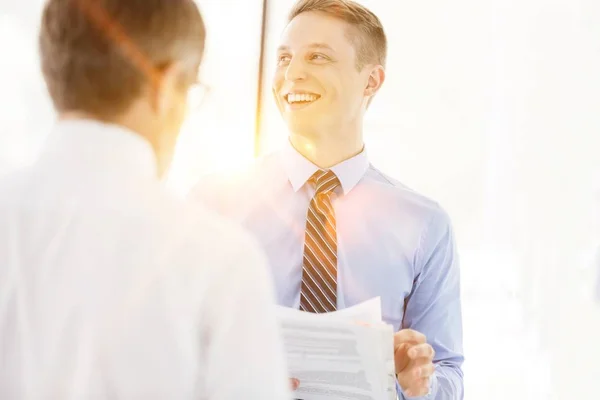 Sorrindo Colegas Negócios Discutindo Sobre Documento Por Parede Escritório — Fotografia de Stock