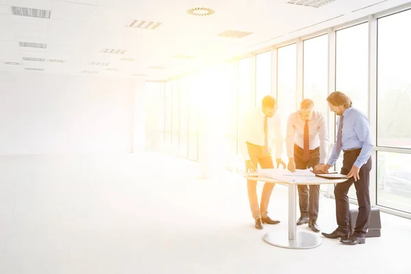 Businessmen Discussing Blueprints Table New Office — Stock Photo, Image