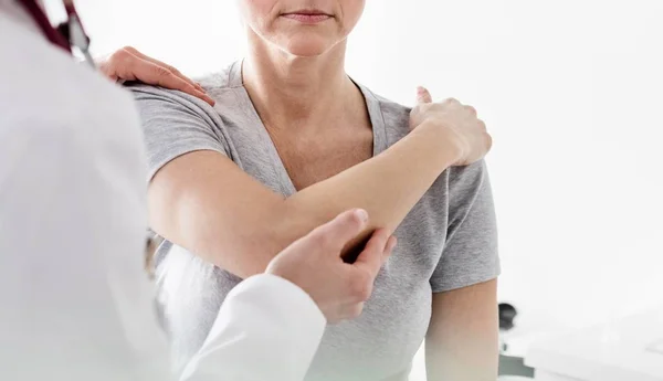 Γιατρός Ελέγχει Τραυματισμένο Χέρι Ασθενούς Στην Κλινική Φωτοβολίδα Φακού — Φωτογραφία Αρχείου