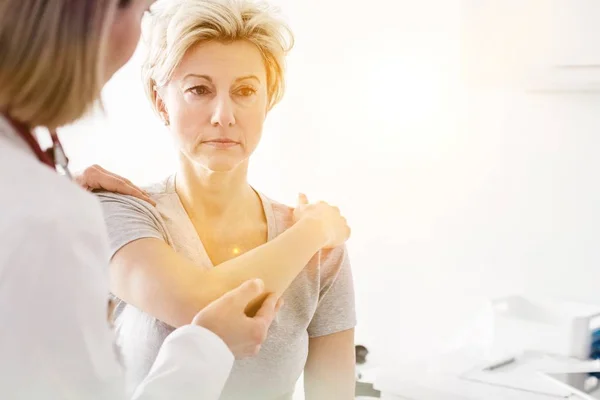 Doctor Checking Injured Patient Arm Clinic Lens Flare — Stock Photo, Image