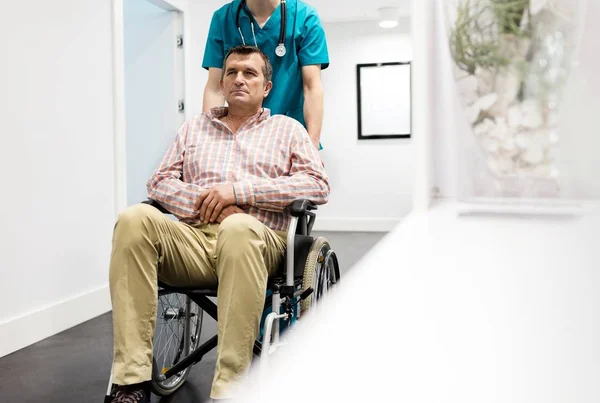 Enfermeira Empurrando Paciente Maduro Sentado Cadeira Rodas Hospital — Fotografia de Stock