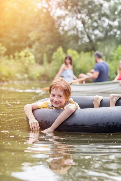 Portret Van Lachende Jongen Drijvend Met Opblaasbare Ring Lake Tegen — Stockfoto