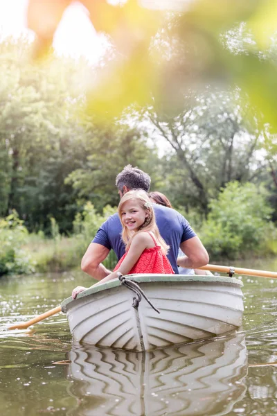 在夏季 可爱的微笑女孩坐在湖上的划艇上与父亲的肖像 — 图库照片