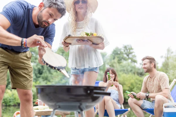 Człowiek Pomocą Mieszków Przygotowywania Potraw Grillu Przyjaciółmi Molo — Zdjęcie stockowe