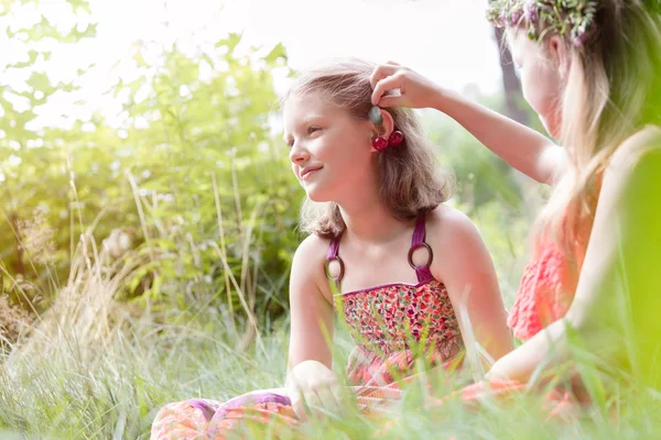 可爱的女孩抱着叶子在朋友的耳朵在公园 — 图库照片
