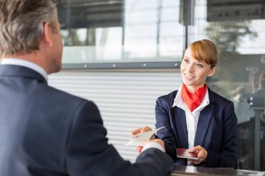 Yolcu hizmetleri acentesi iş adamlarına pasaport ve uçuş kartı veriyor.