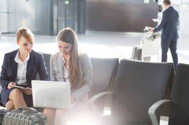 Havaalanında yolcu beklerken iş adamları çalışıyor.