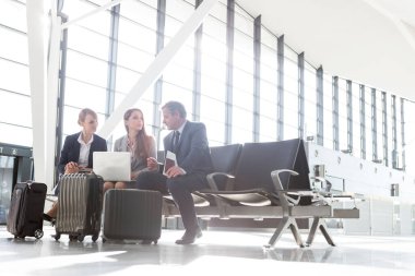 Havaalanında yolcu beklerken iş adamları çalışıyor.