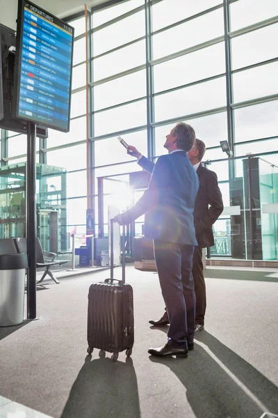 Retrato Empresários Maduros Olhando Para Seu Voo Monitor Aeroporto — Fotografia de Stock