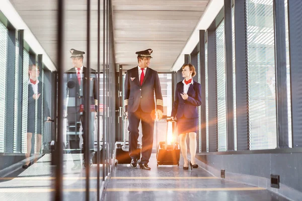 Portret Van Volwassen Piloot Wandelen Met Jonge Aantrekkelijke Stewardess Luchthaven — Stockfoto