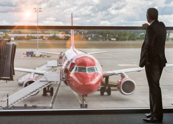 空港の飛行機を見ながら立つ熟年実業家 — ストック写真
