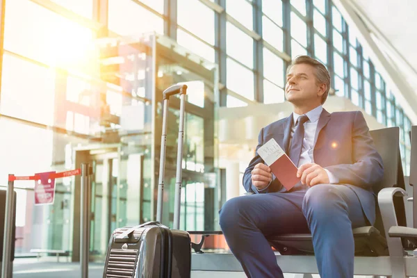 Yetişkin Bir Işadamının Portresi Havaalanında Yolcu Beklerken Elinde Pasaportuyla Oturuyor — Stok fotoğraf