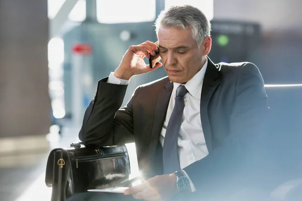 Adamı Oturmuş Havaalanında Binmek Için Beklerken Akıllı Telefondan Konuşuyor — Stok fotoğraf