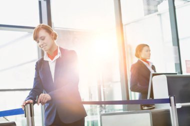 Çekici genç yolcu hizmetleri görevlisinin portresi havaalanında yolcu alımı için kapıyı açıyor.